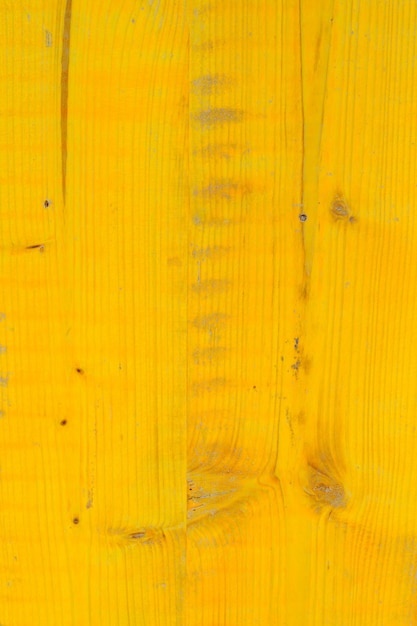 Fondo de madera con textura de tableros con nudos y rasguños en amarillo brillante