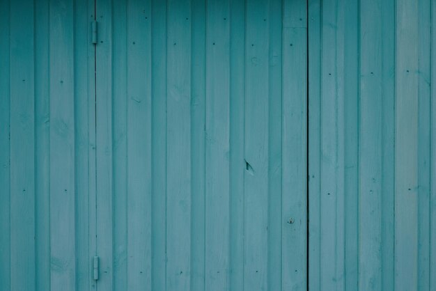 Fondo de madera verde cerca de la pared hecha de tablones de madera verticales azules