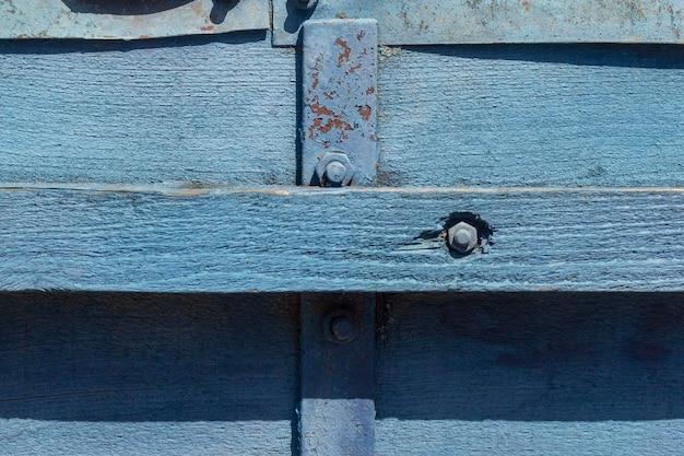 Fondo de madera vieja pared de madera pintada de azul con rendijas y clavos