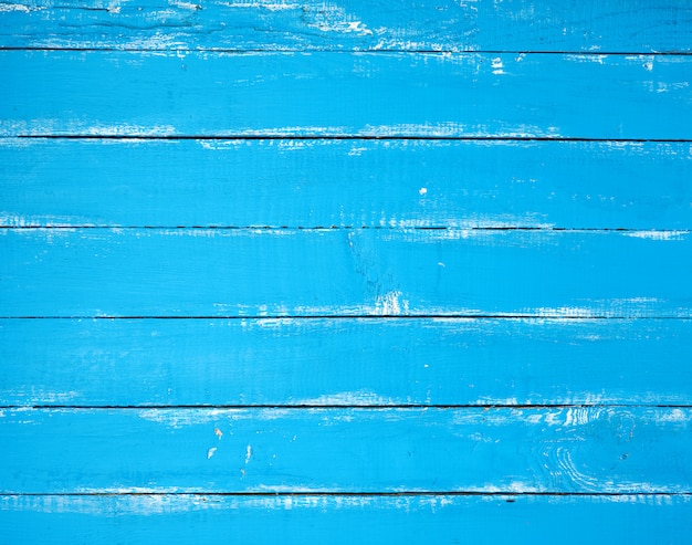 Fondo de madera vieja con pintura agrietada azul, tablas paralelas