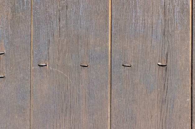 Foto fondo de madera vieja con tablas verticales desgastadas y remaches metálicos