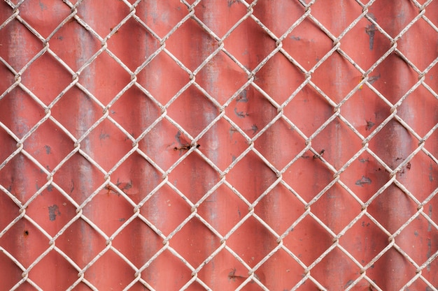 Fondo de malla de alambre y valla corrugada roja