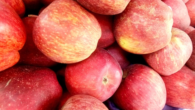 Fondo de manzanas crujientes de miel roja fresca escogida en la temporada de cosecha colocada en un mercado o bazar para la venta