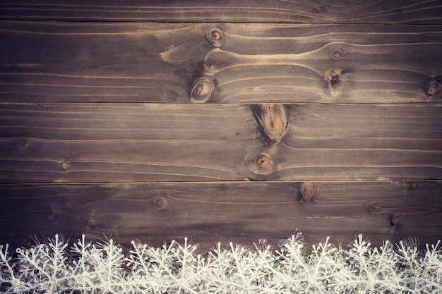 Fondo marrón de madera de la Navidad y copos de nieve blancos con el espacio.