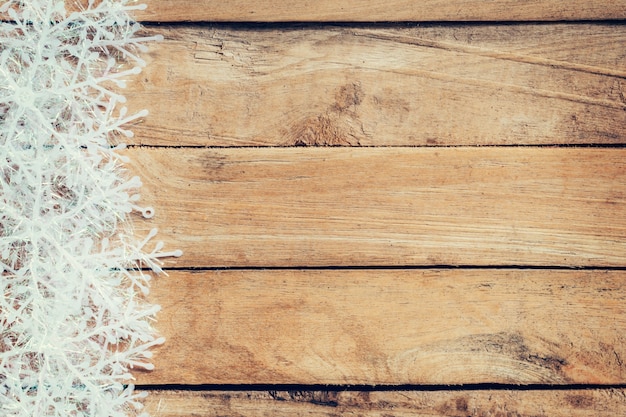 Foto fondo marrón de madera de la navidad y copos de nieve blancos con el espacio.