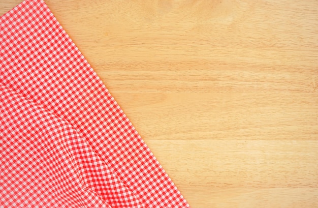 Fondo de mesa de madera con tela a cuadros rosa arrugada o mantel en la esquina