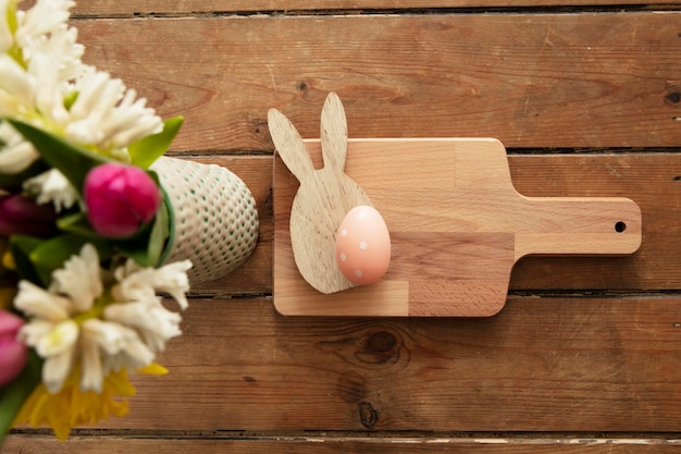 Fondo de mesa de pascua flores de primavera con un conejito de madera y huevos de pascua