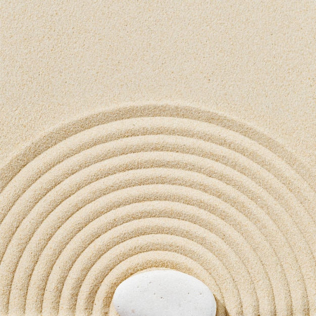Fondo mínimo estético con piedras zen en patrón de arena en jardín zen japonés con círculos