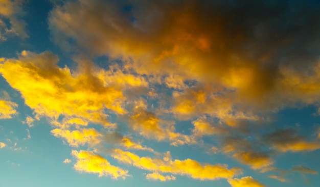 Foto fondo con muchas nubes amarillas y naranjas sobre cielo azul claro