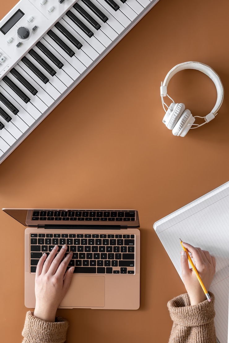 Foto fondo musical con teclas musicales, portátil y manos femeninas, vista superior.