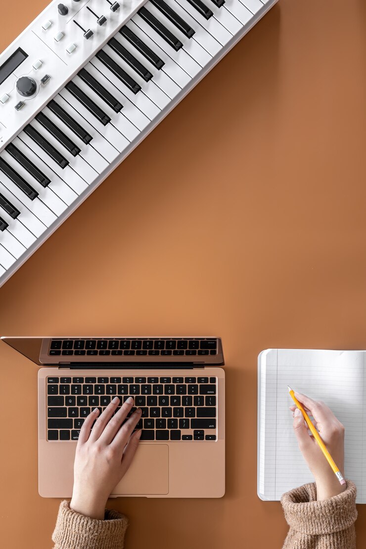 Foto fondo musical con teclas musicales, portátil y manos femeninas, vista superior.