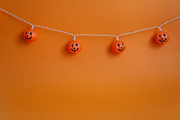 Fondo naranja con elementos decorativos para halloween. Calabaza aterradora de Halloween