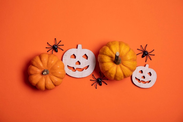 Fondo naranja de halloween con calabazas y arañas