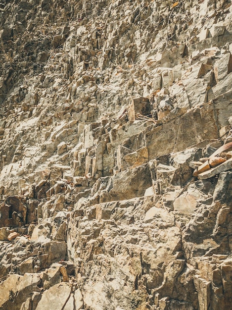 Fondo natural Grietas de acantilado en mal estado con bordes de primer plano Textura de roca de piedra gris marrón de las montañas Color de estilo mate vintage y descolorido en foto teñida Concepto de montañismo geológico o trabajo duro