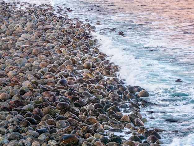 Fondo natural de guijarros a la orilla del mar