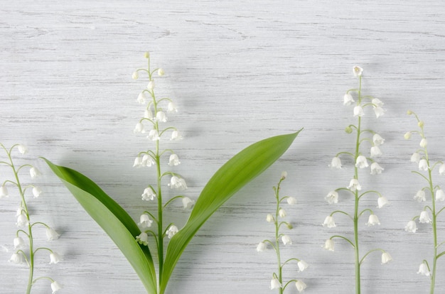 Foto fondo natural de primavera con flores de lirio de los valles en la mesa de madera