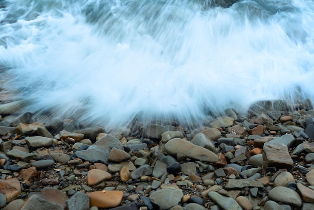 Fondo de naturaleza con olas de mar golpeando la orilla del mar Vista panorámica del mar contra el cielo nublado