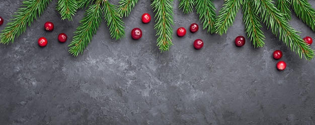 Fondo de Navidad con abeto y arándano rojo sobre mesa de piedra oscura