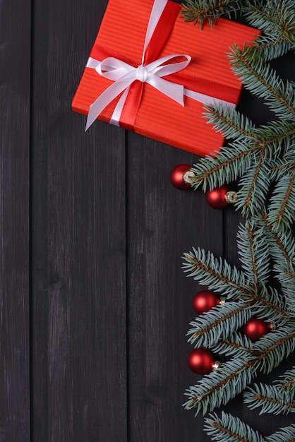 Fondo de Navidad con abeto y caja de regalo en tablero de madera negra