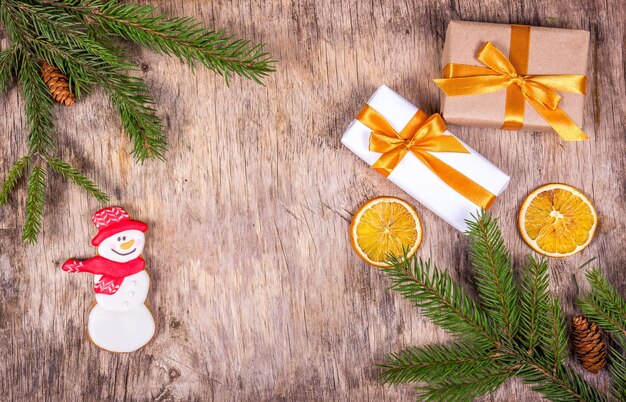 Fondo de Navidad con abeto, cajas de regalo y muñeco de nieve de jengibre