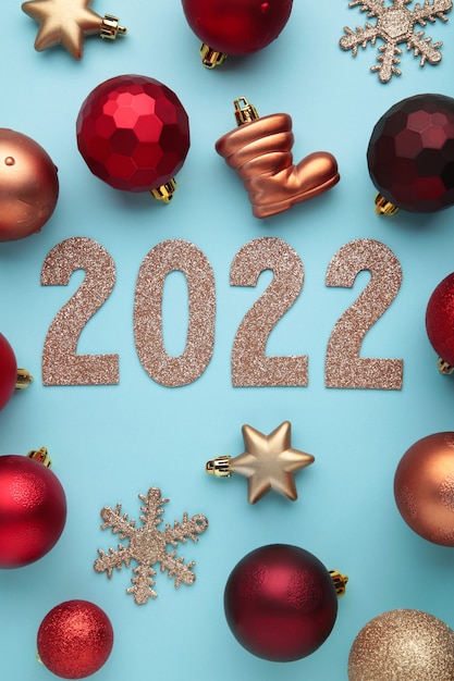 Foto fondo de navidad con abetos, conos de abeto y adornos navideños y números 2022. concepto de año nuevo en azul. foto vertical