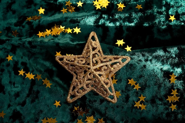 Fondo de Navidad abstracto con estrellas doradas en un fondo de terciopelo verde