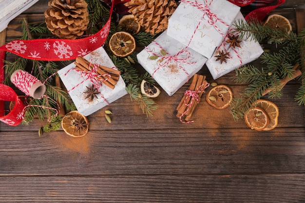 Fondo de Navidad con adornos y cajas de regalo en tablero de madera oscura.