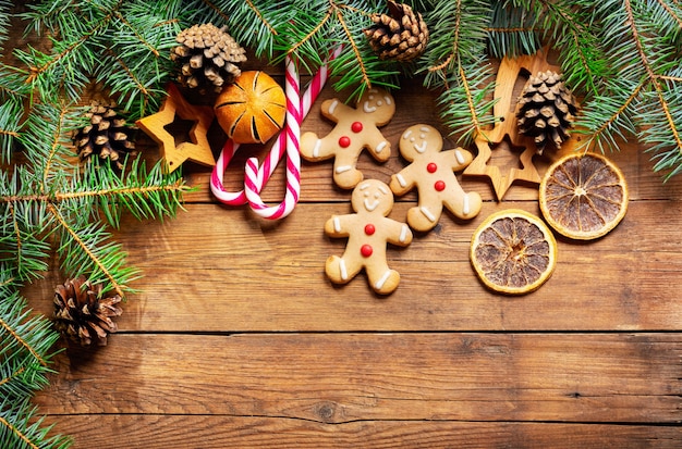 Fondo de Navidad con adornos de galletas de jengibre y ramas de abeto fresco