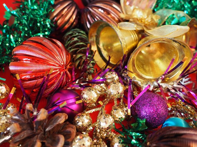 Fondo de Navidad con adornos navideños, bolas navideñas, campanas, arcos, cono de abeto, árbol de Navidad, lluvia, feliz año nuevo y feliz Navidad, rojo, marrón, rayas, verde, oro, púrpura, colorido, decoración