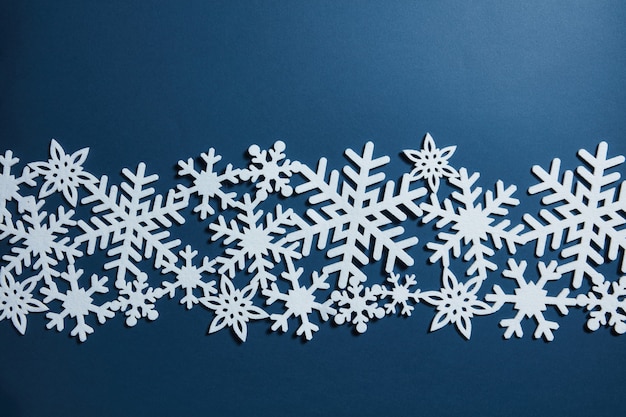 Fondo de Navidad azul con copos de nieve blancos. Postal navideña
