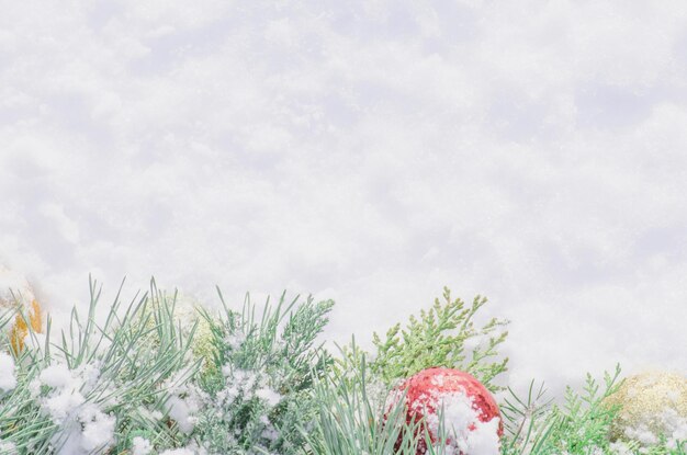 Fondo de navidad con bolas y decoraciones sobre fondo blanco de nieve Ramas de árboles de navidad con adornos dorados y rojos sobre nieve blanca Vista superior plana