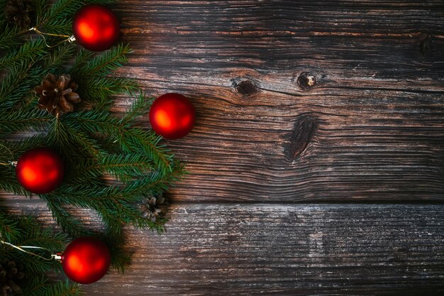 Fondo de Navidad con bolas rojas, ramas de abeto y piñas