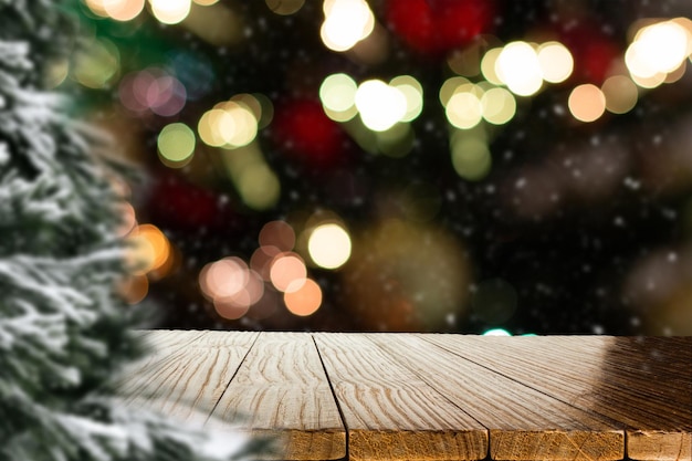 Fondo de Navidad borroso con mesa de madera vacía en foco Pantalla vacía para ensamblaje de productos