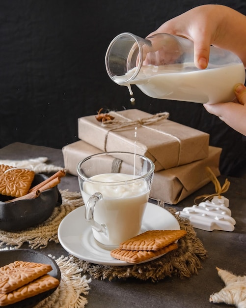 Foto fondo de navidad con botella y un vaso con leche, galletas, cajas envueltas.