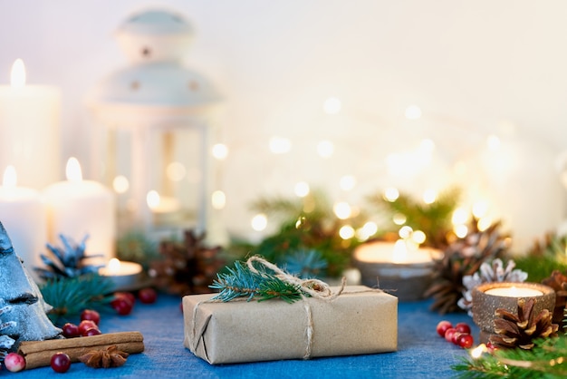 Fondo de Navidad con caja de regalo y guirnaldas de adornos, velas y luces.