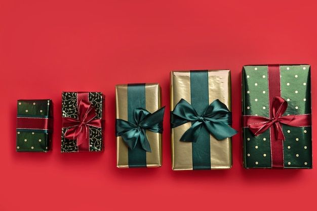 Fondo de Navidad con cajas de regalo con cintas de raso sobre fondo rojo.