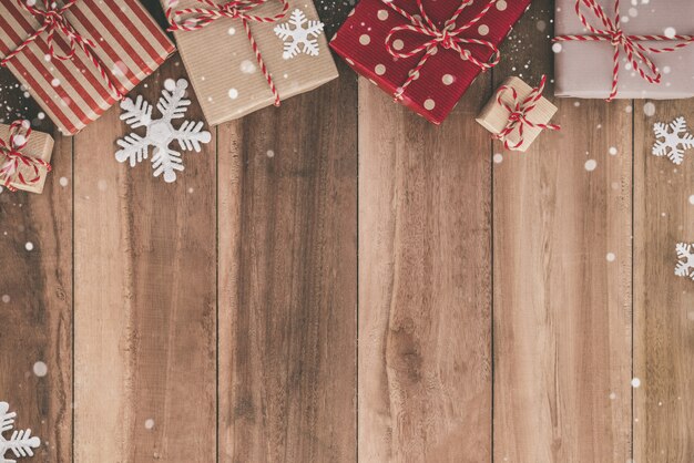 Fondo de Navidad con cajas de regalo y decoración de copos de nieve en una mesa de madera