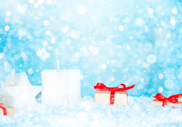 Fondo de Navidad con cajas de regalo y velas en la nieve