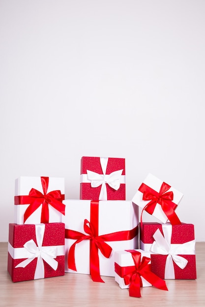 Fondo de Navidad de cerca de cajas de regalos rojas y blancas en el suelo de madera con espacio de copia