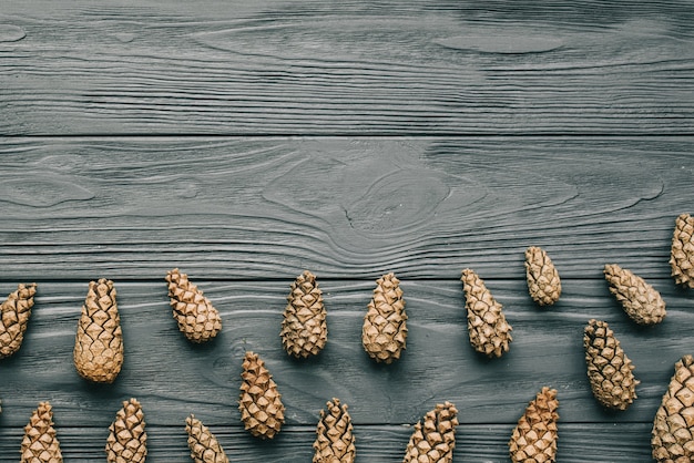 Fondo de Navidad con conos de pino en un tablero de madera gris