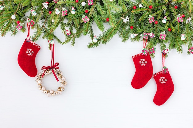 Fondo de Navidad decorado árbol de Navidad corona de Navidad y calcetines rojos sobre madera blanca