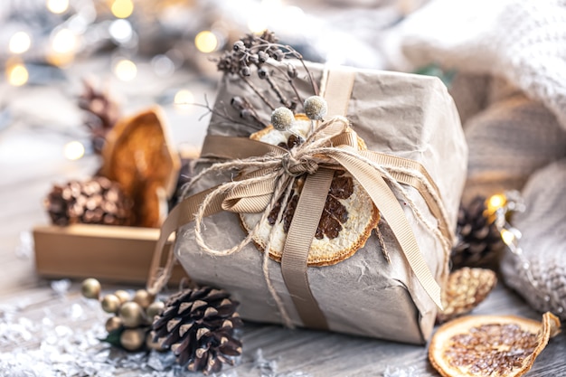 Fondo de Navidad festiva con caja de regalo sobre fondo borroso con detalles de decoración.