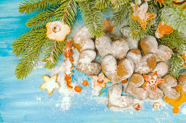 Fondo de navidad con galletas de ramas de abeto espolvoreadas con azúcar en polvo sobre tabla de madera