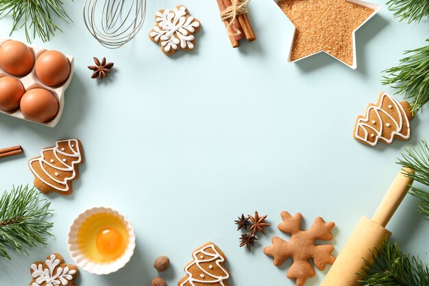 Fondo de Navidad para hornear con galletas e ingredientes sobre fondo azul. Copie el espacio. Vista desde arriba.