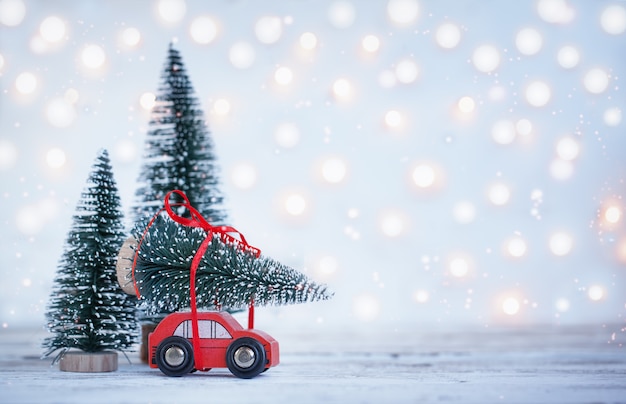 Fondo de Navidad de invierno Miniatura coche rojo con abeto. Tarjeta de felicitación navideña.