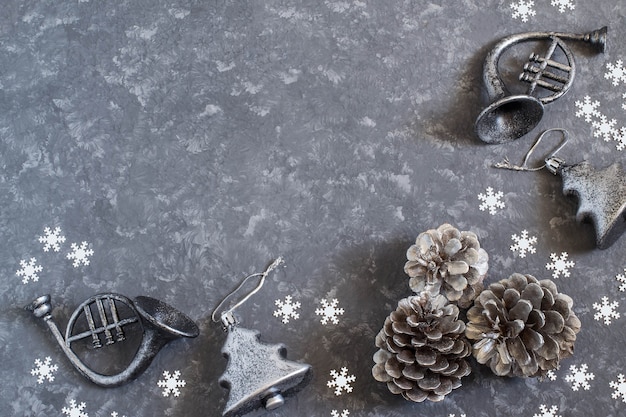 Fondo de Navidad con juguetes de Navidad plateados vintage y conos sobre superficie de hormigón gris