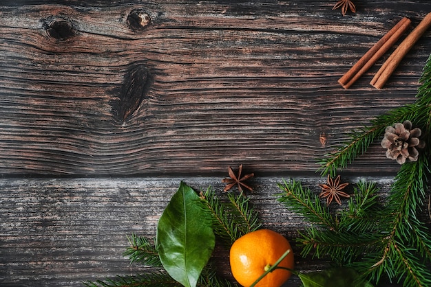 Fondo de Navidad con mandarinas, ramas de abeto, canela y anís estrellado.