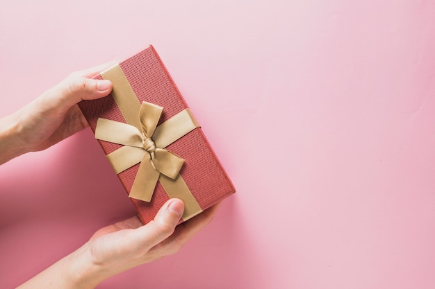 Foto fondo de navidad con manos sujetando caja de regalo