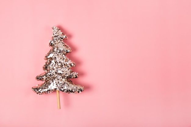 Fondo de navidad moderno con árbol de navidad dorado sobre un fondo rosa copia espacio para texto