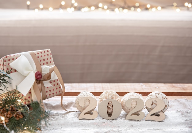 Fondo de Navidad con números de madera 2022 y detalles de decoración sobre fondo borroso con luces bokeh,